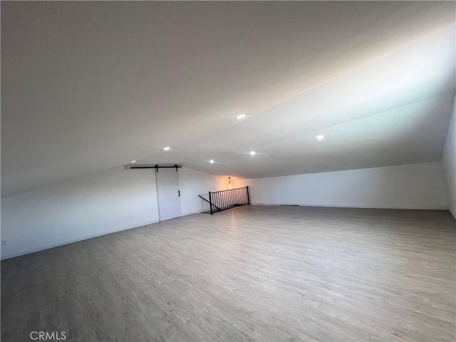 bonus room with lofted ceiling and hardwood / wood-style floors