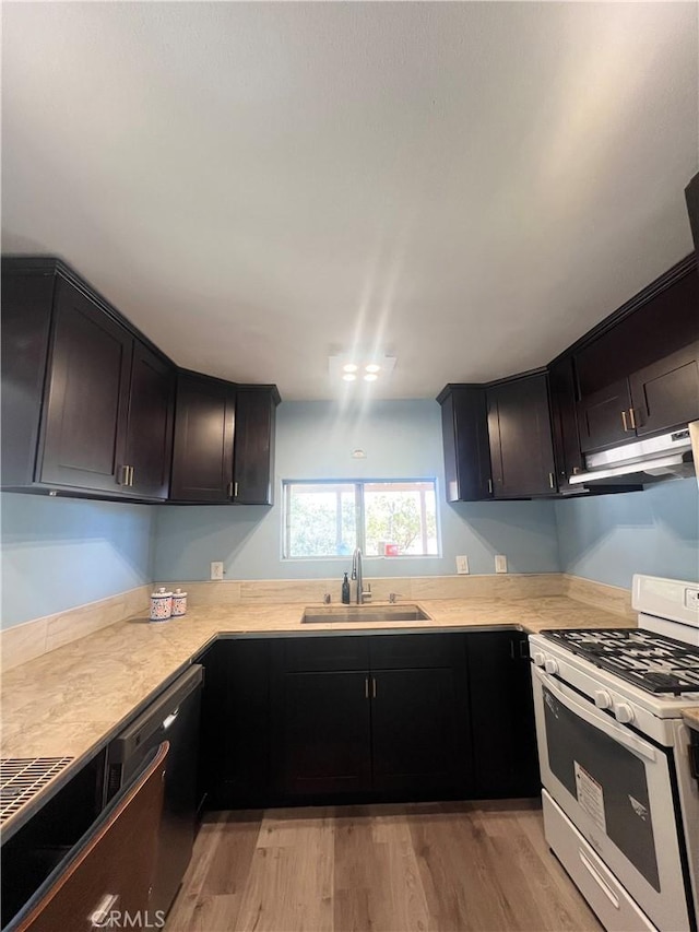 kitchen with dishwasher, sink, white gas range, and light hardwood / wood-style floors