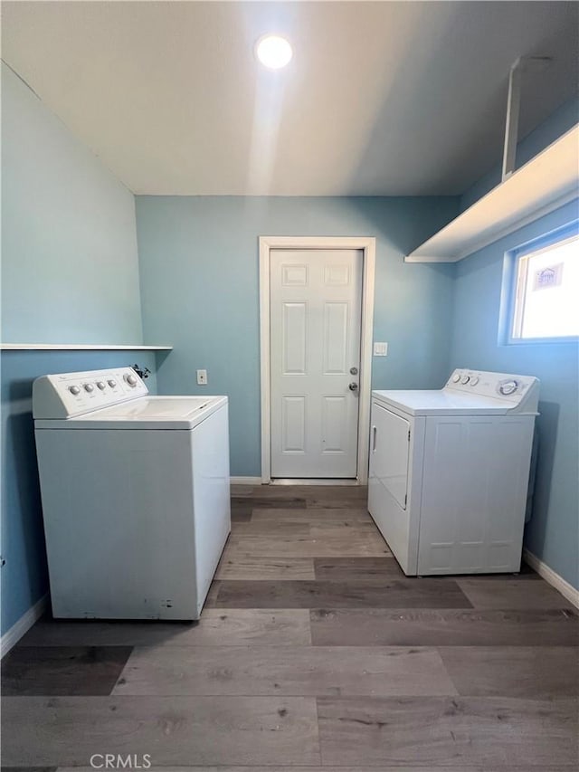 clothes washing area featuring washing machine and dryer and light hardwood / wood-style floors