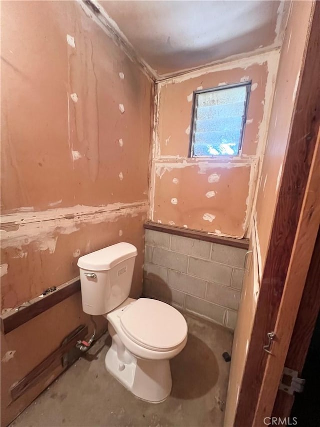 bathroom featuring toilet and concrete flooring