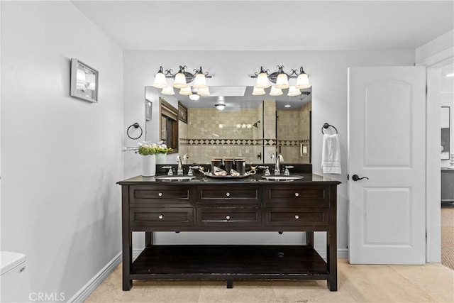 bathroom featuring toilet, vanity, a tile shower, and tile patterned flooring