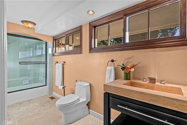 full bathroom with enclosed tub / shower combo, vanity, and toilet