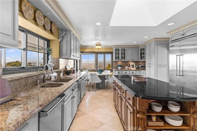 kitchen with a wealth of natural light, a skylight, appliances with stainless steel finishes, and sink