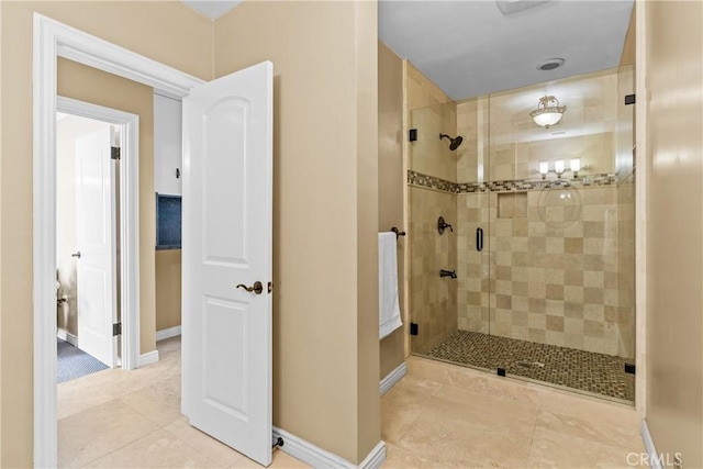 bathroom with a shower with shower door and tile patterned flooring