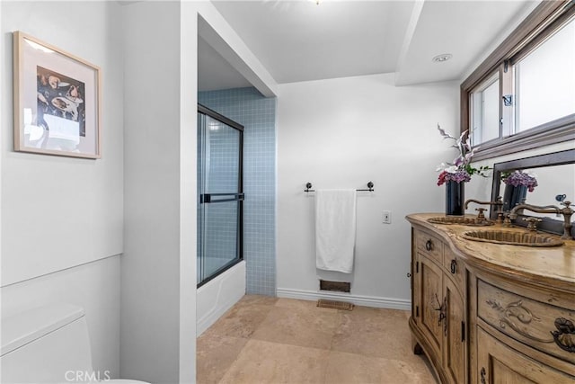 full bathroom featuring toilet, combined bath / shower with glass door, and vanity