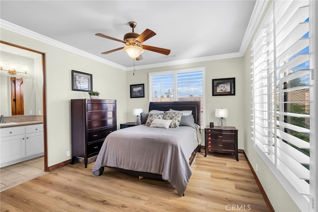 bedroom with ceiling fan, light hardwood / wood-style floors, sink, and ensuite bath