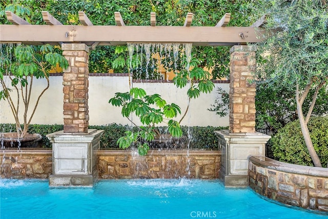 view of swimming pool featuring pool water feature and a pergola