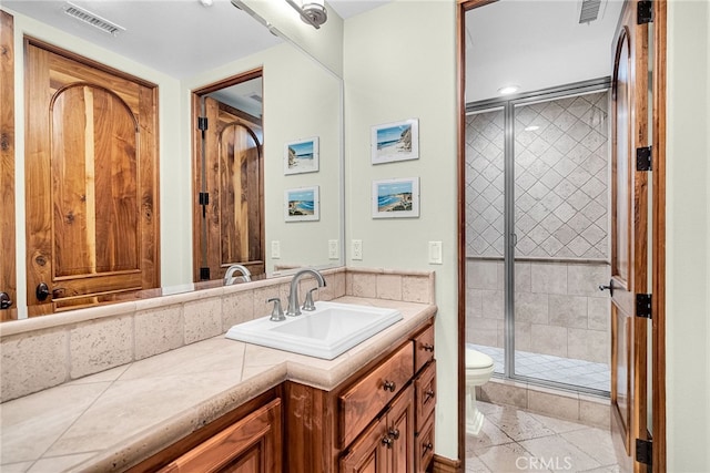 bathroom with toilet, a shower with door, tile patterned floors, and vanity