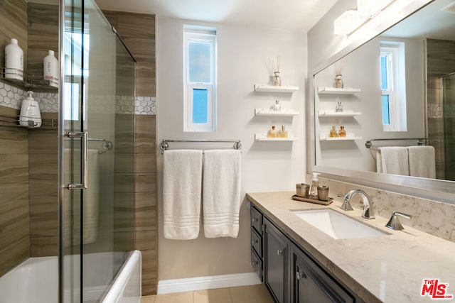 bathroom featuring vanity and shower / bath combination with glass door