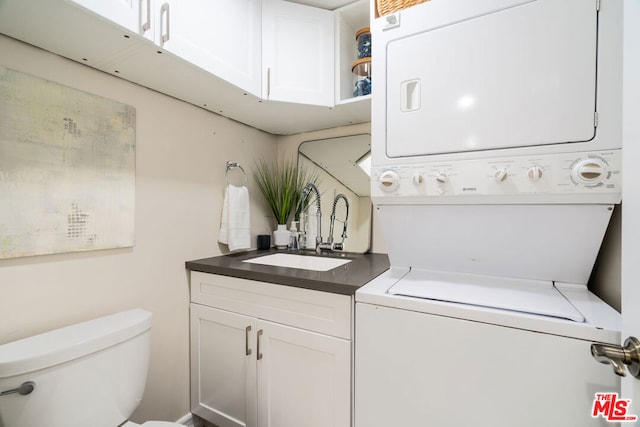 laundry room featuring stacked washer / drying machine and sink