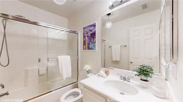 full bathroom featuring toilet, combined bath / shower with glass door, and vanity