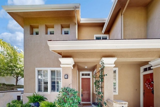 doorway to property featuring stucco siding