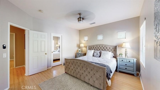 bedroom with ceiling fan, light wood finished floors, and visible vents