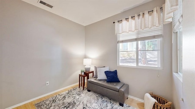 living area featuring visible vents, baseboards, and wood finished floors