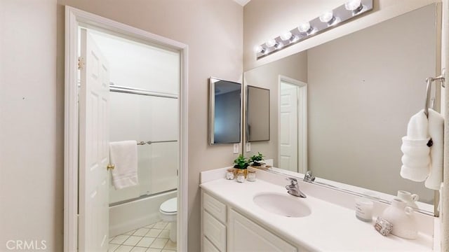 bathroom with toilet, bath / shower combo with glass door, tile patterned flooring, and vanity