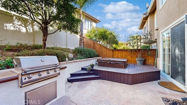 view of patio featuring a fenced backyard, area for grilling, a grill, and a covered hot tub