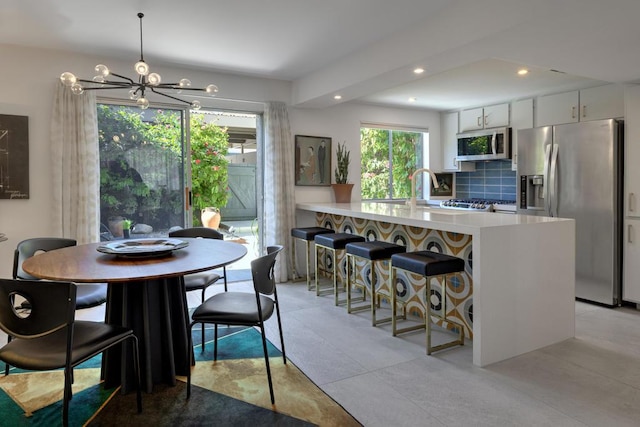 dining area with sink and an inviting chandelier