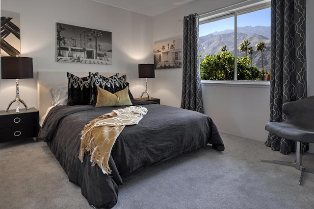 bedroom featuring a mountain view, light colored carpet, and multiple windows