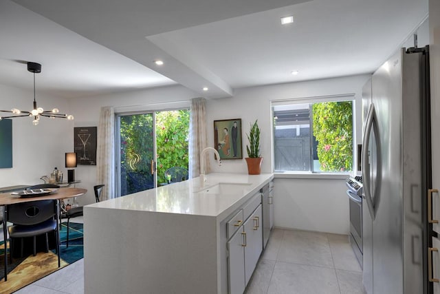 kitchen with stainless steel appliances, sink, hanging light fixtures, kitchen peninsula, and a chandelier