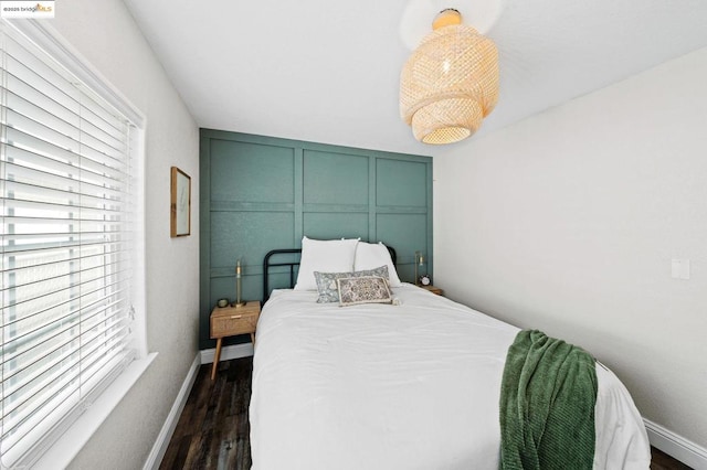 bedroom with dark hardwood / wood-style flooring