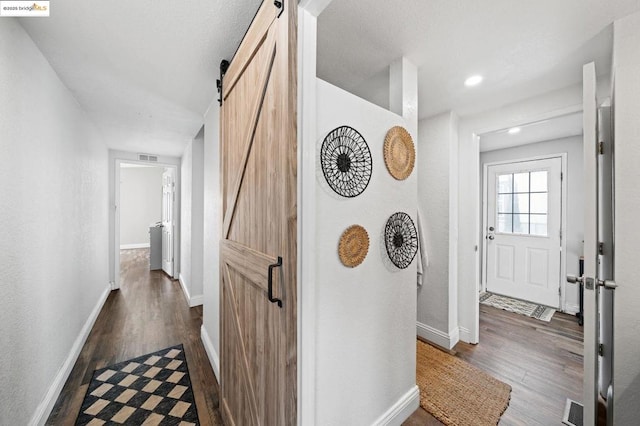 hall featuring dark hardwood / wood-style floors and a barn door