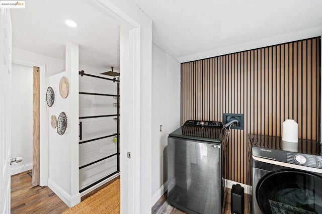 laundry room featuring wood-type flooring and washer / dryer