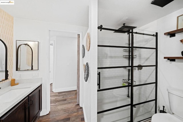 bathroom featuring tiled shower, vanity, toilet, and hardwood / wood-style floors