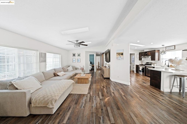 living room featuring ceiling fan, dark hardwood / wood-style flooring, sink, and a wealth of natural light