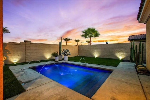 pool at dusk featuring pool water feature