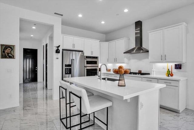 kitchen with sink, stainless steel appliances, white cabinets, and wall chimney exhaust hood