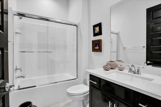 full bathroom featuring enclosed tub / shower combo, vanity, and toilet