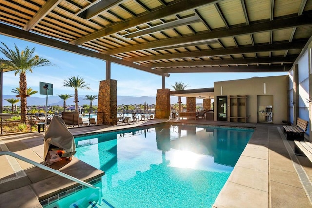 view of swimming pool with a pergola and a mountain view