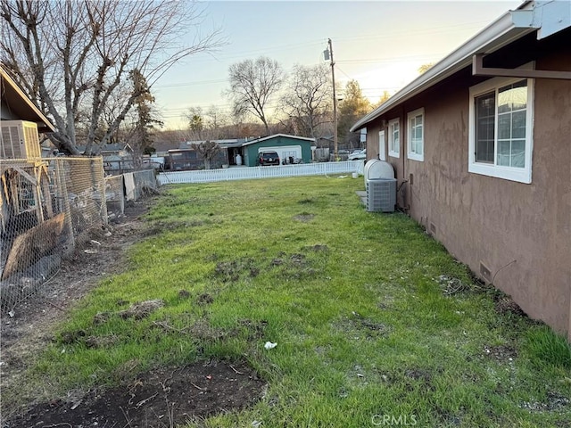 yard at dusk featuring central AC unit