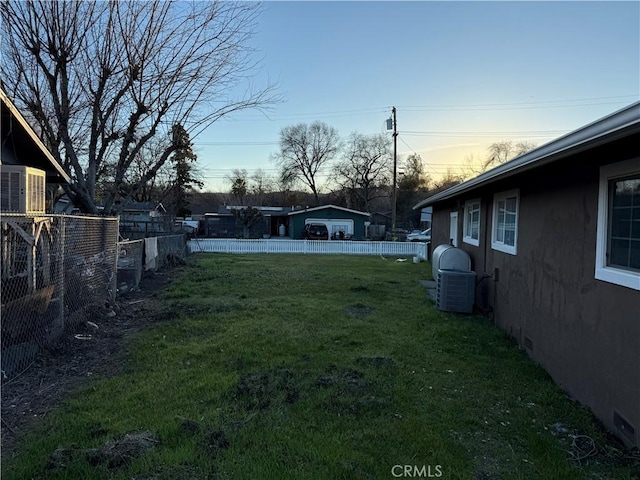 yard at dusk featuring central AC