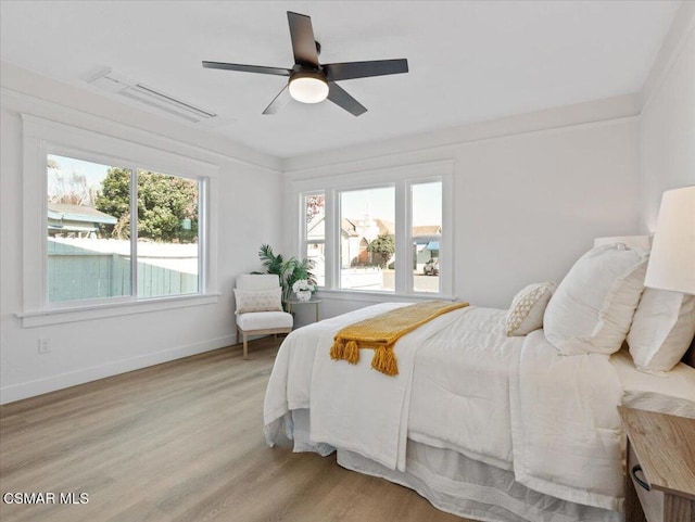 bedroom featuring ceiling fan, light wood-type flooring, and ornamental molding