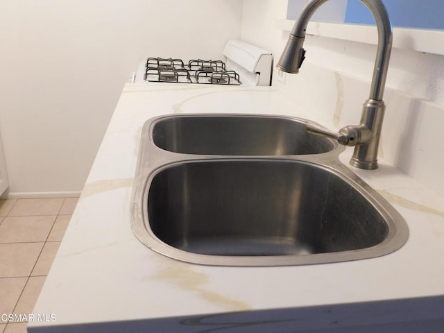 room details featuring light stone countertops and sink