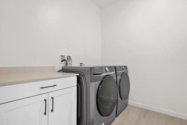 washroom with washing machine and dryer and cabinets