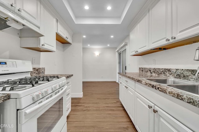 kitchen with sink, light hardwood / wood-style flooring, white cabinetry, and white range with gas stovetop