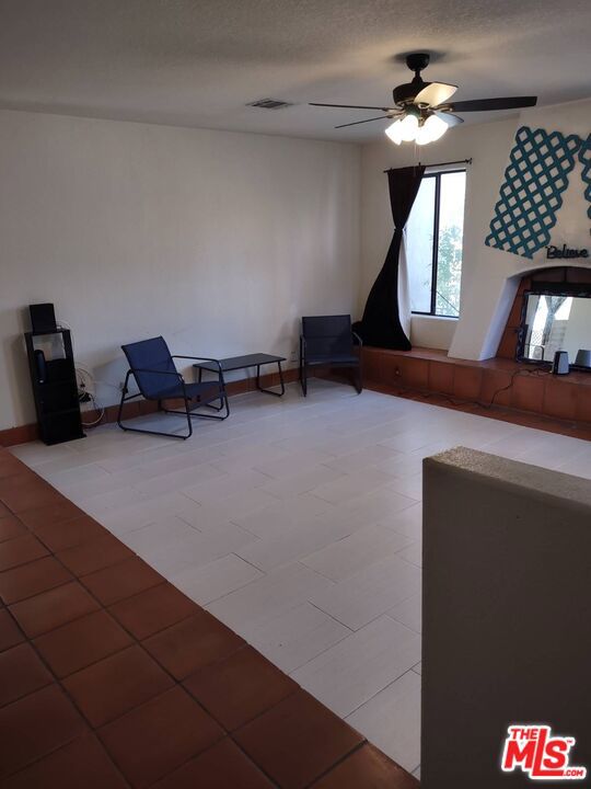 unfurnished room with ceiling fan and a textured ceiling