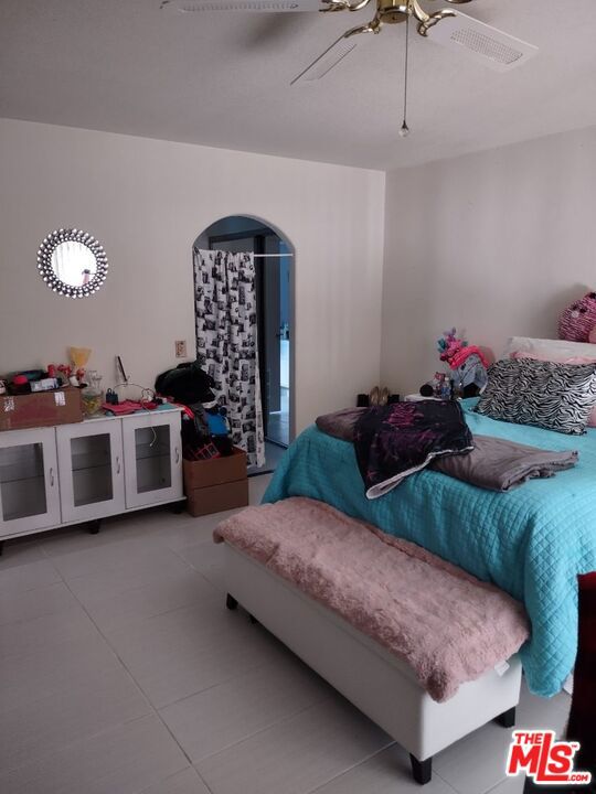 bedroom with ceiling fan and tile patterned floors