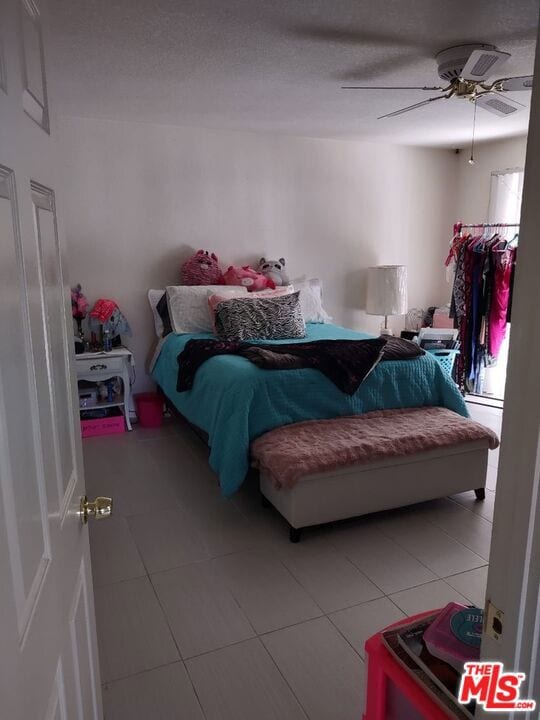 tiled bedroom with ceiling fan