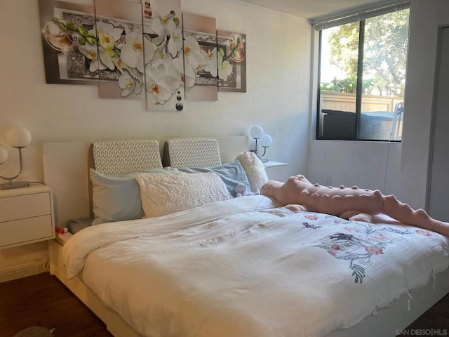 bedroom featuring dark wood-type flooring and access to outside