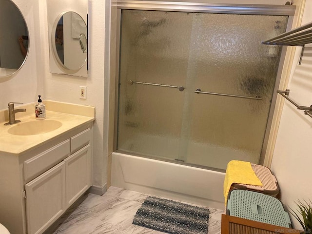 bathroom featuring combined bath / shower with glass door and vanity