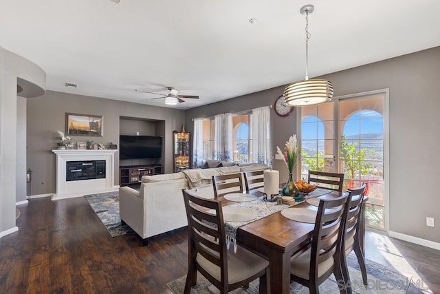 dining space featuring ceiling fan, a healthy amount of sunlight, and dark hardwood / wood-style floors