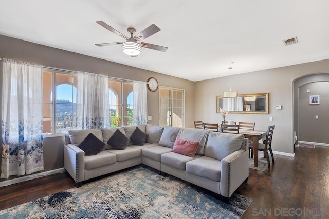 living room featuring ceiling fan and dark hardwood / wood-style flooring