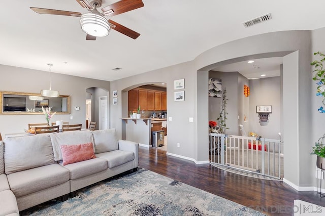 living room featuring ceiling fan and dark hardwood / wood-style flooring