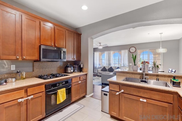 kitchen with light tile patterned floors, ceiling fan, appliances with stainless steel finishes, tasteful backsplash, and decorative light fixtures