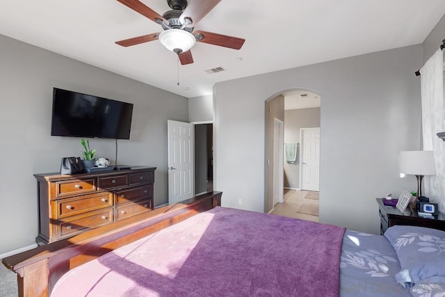 carpeted bedroom featuring ceiling fan and ensuite bathroom