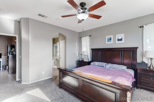 carpeted bedroom with ceiling fan and ensuite bathroom