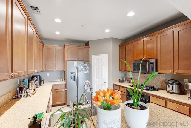 kitchen with light stone countertops and appliances with stainless steel finishes